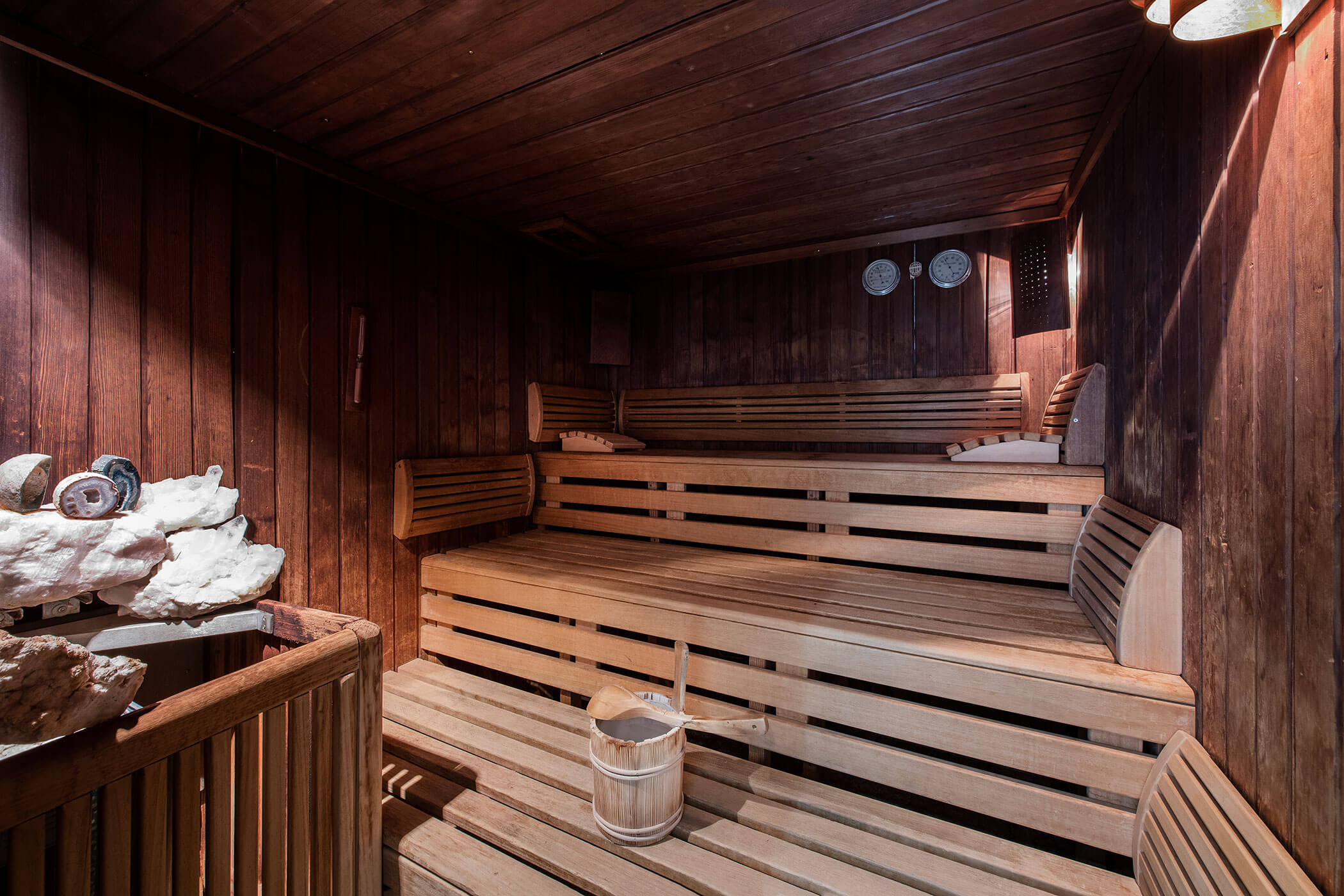 Una sauna in legno con una panca in legno, creando un ambiente caldo e accogliente per il relax.