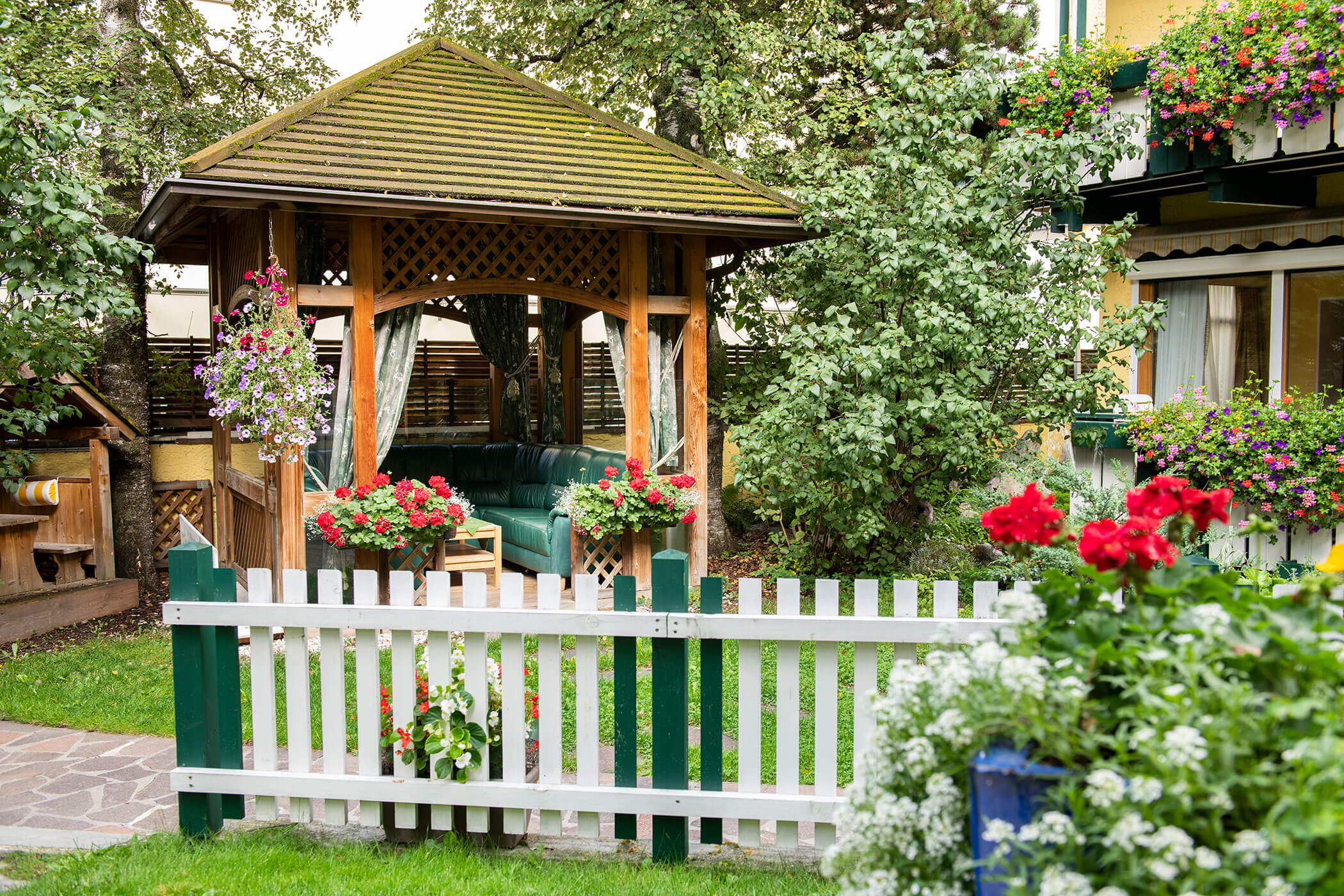 Recinzione bianca a picket che delimita un giardino, con un aspetto tradizionale e accogliente.
