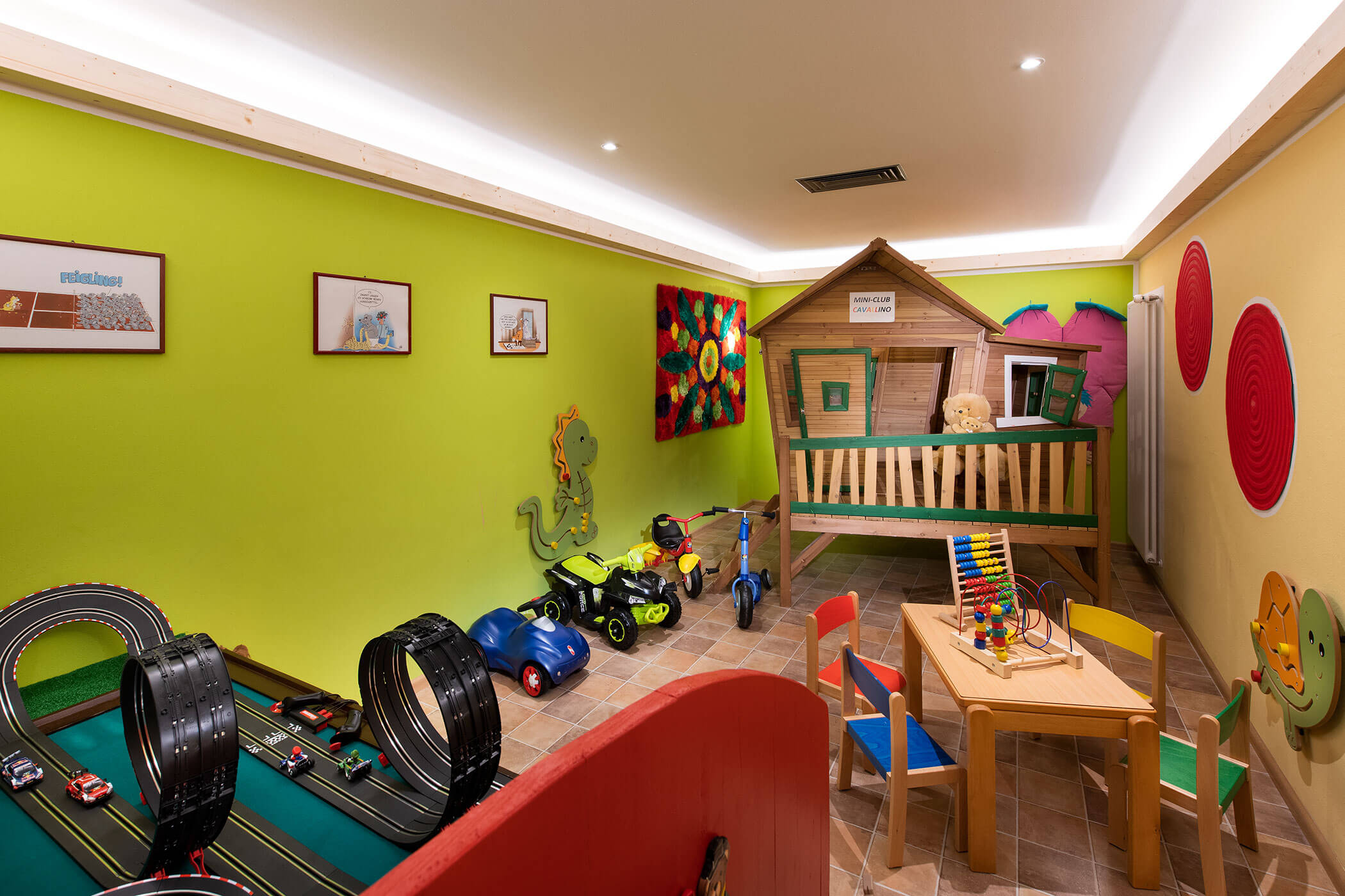 Una stanza giochi con un'auto giocattolo e una casetta per bambini.