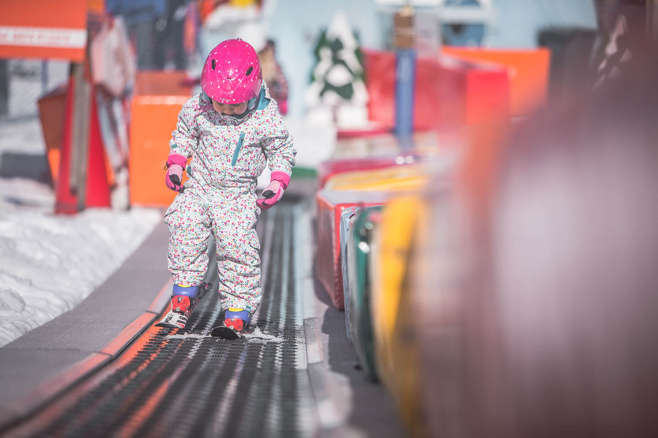 Una giovane ragazza sugli sci su un tracciato coperto di neve.