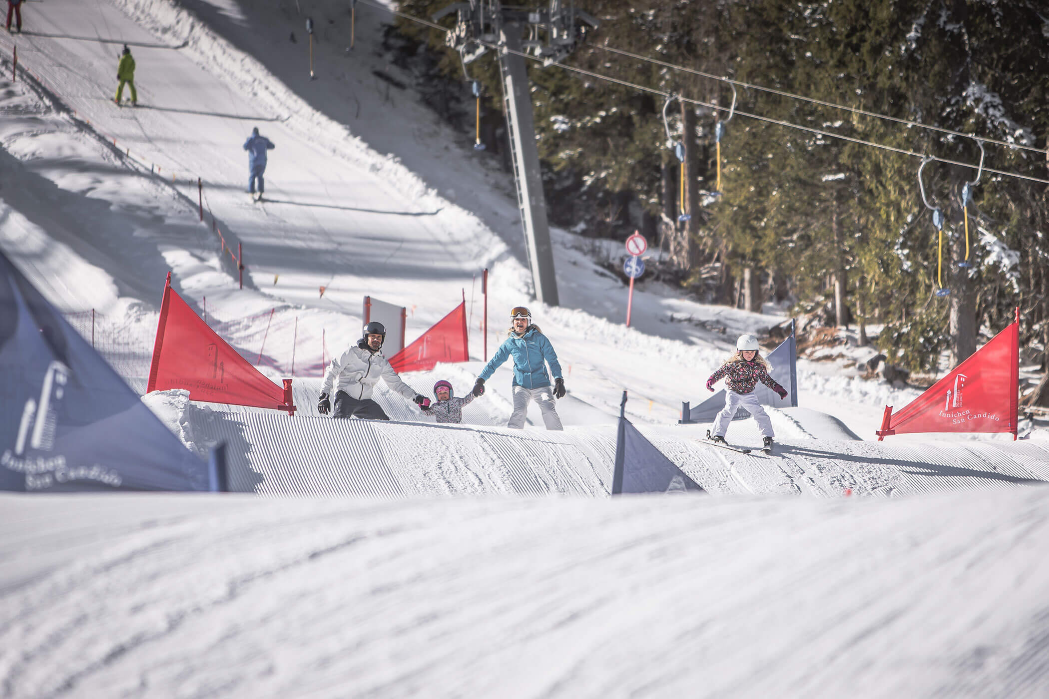 Un gruppo di persone scia giù per una pista innevata, godendo della giornata di sport invernale.