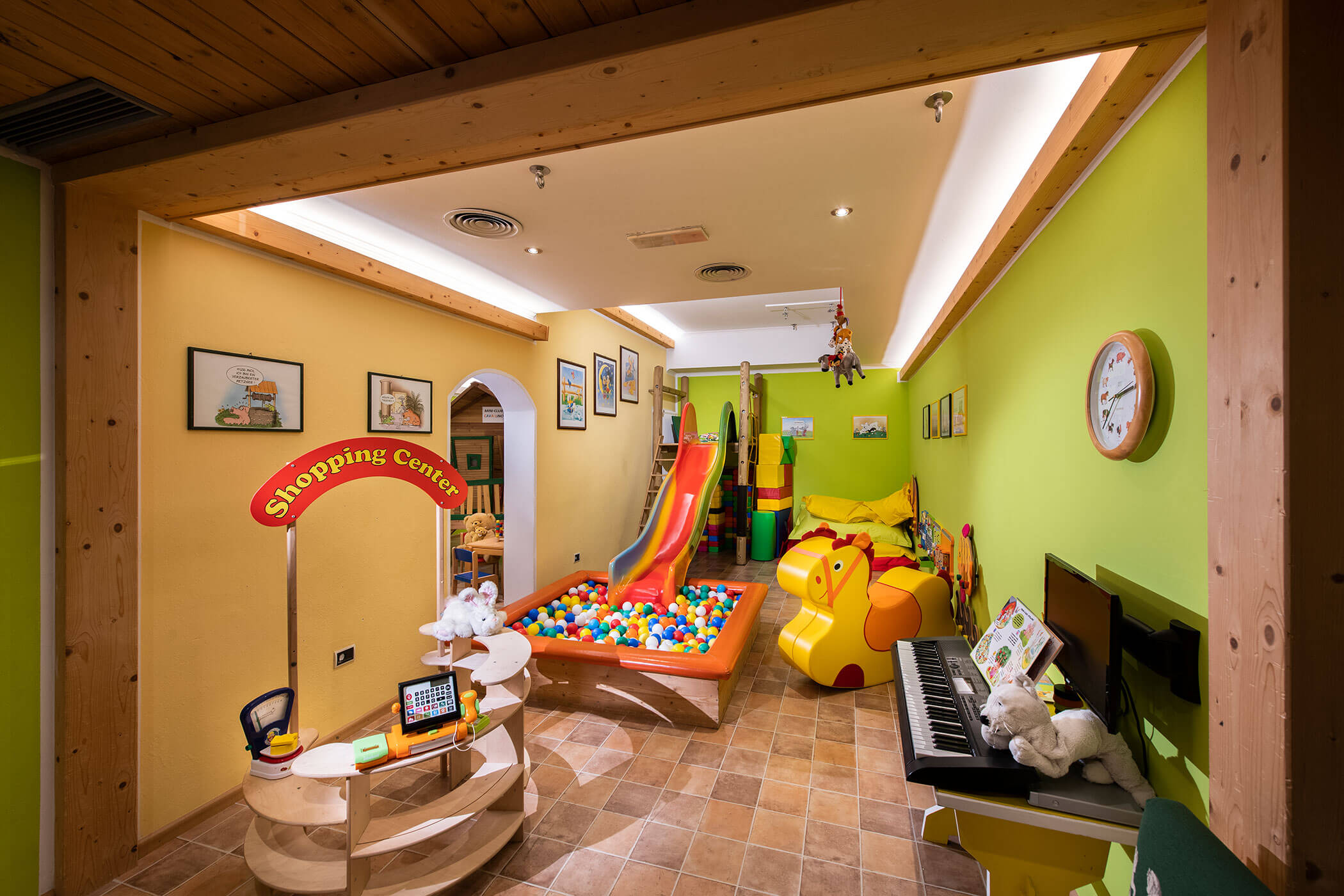 Una stanza con un'area giochi colorata e sicura per bambini, con giocattoli e tappeti morbidi.