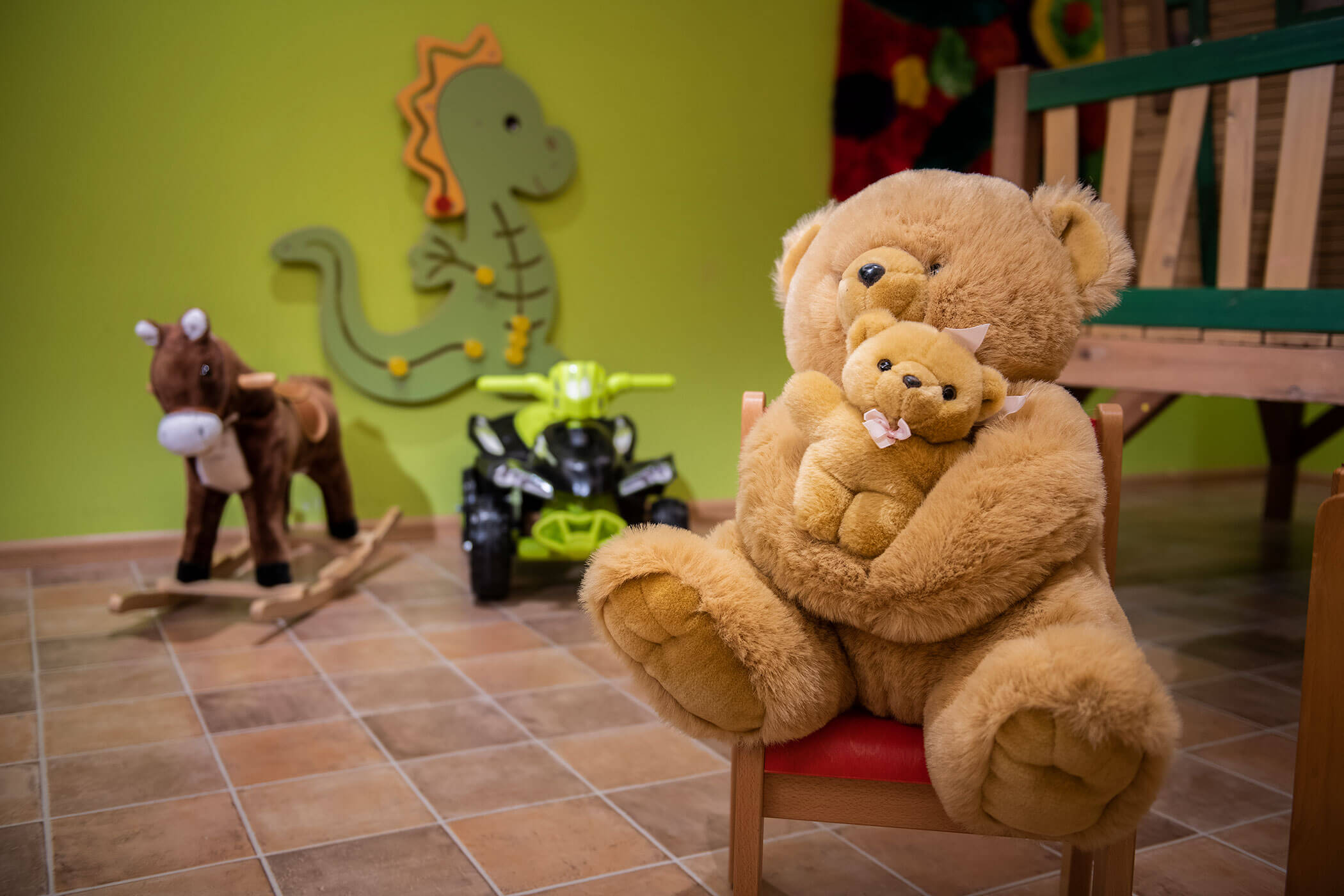 Un orsetto di peluche è seduto su una sedia in una stanza.