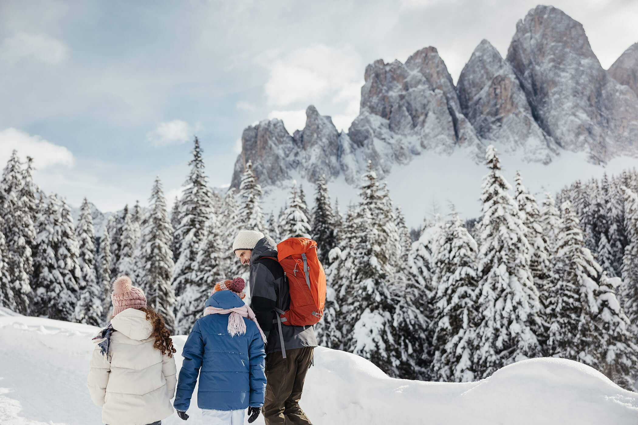 Una famiglia con zaini cammina attraverso la neve.