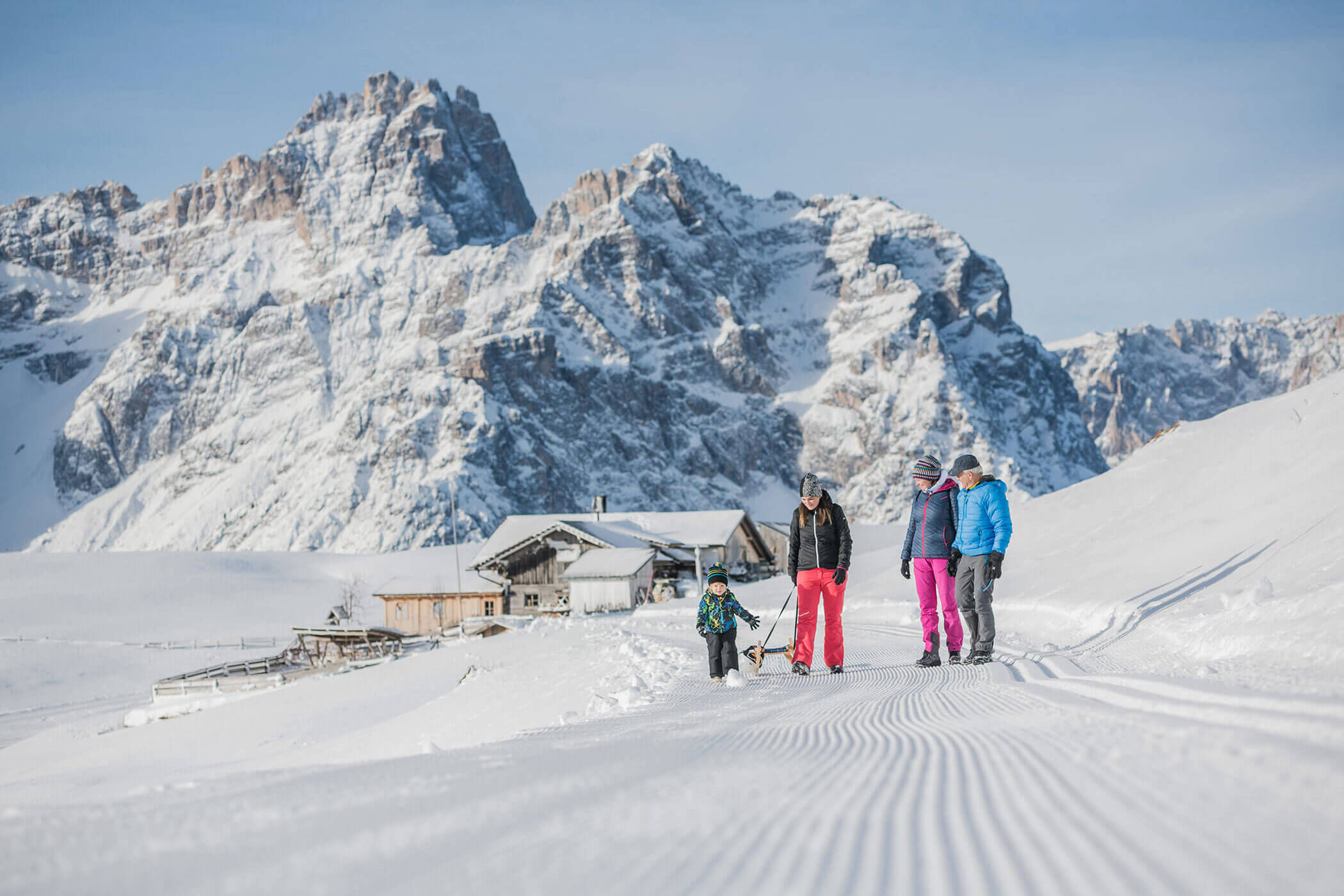 Un gruppo di persone cammina sulla neve davanti a una montagna imponente.